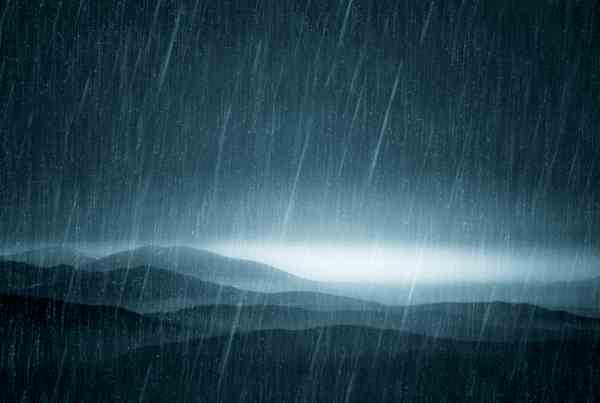heavy rain falling over a hilly landscape